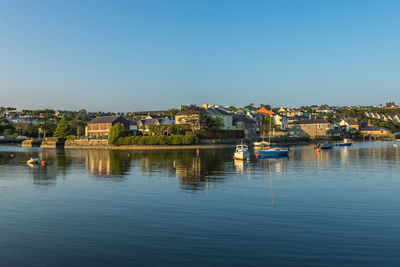 Townscape by river against clear sky