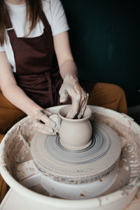 Midsection of woman making pot