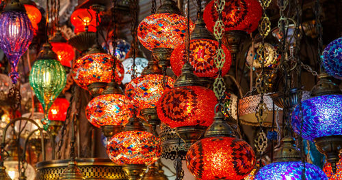 Illuminated lanterns hanging at market stall