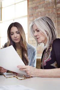 Businesswoman examining document at desk in board room