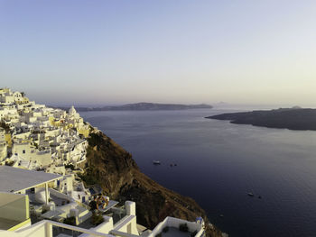 High angle view of townscape by sea against clear sky