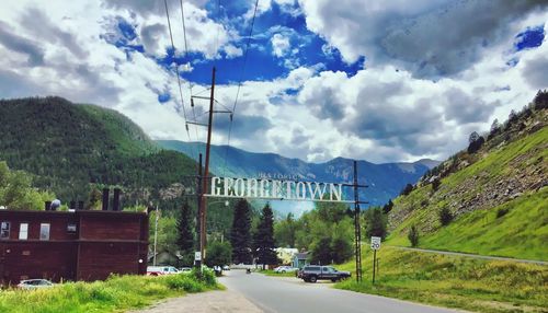 Road by mountains against sky