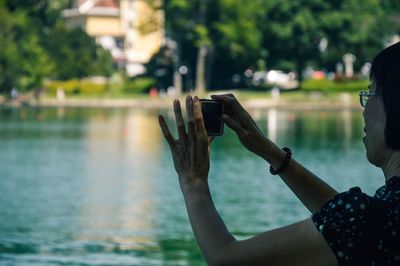 Close-up of woman photographing with mobile phone