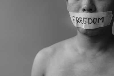 Close-up of shirtless man against white background