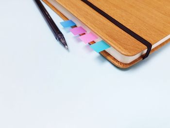 A pen with notebook on blue background