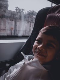 Portrait of boy looking through car window