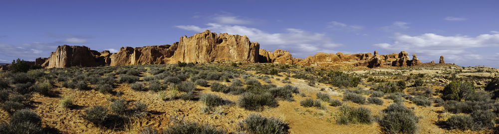 View of rocks on landscape against cloudy sky