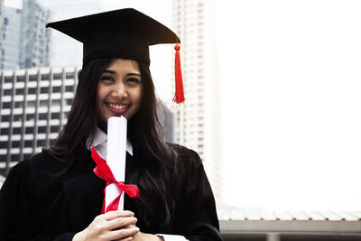 Young woman standing against building