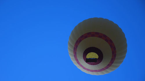 Low angle view of hot air balloons against clear blue sky