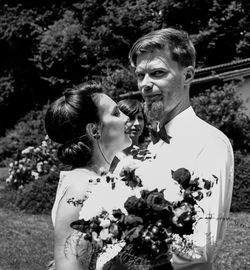 Close-up of couple holding flower bouquet