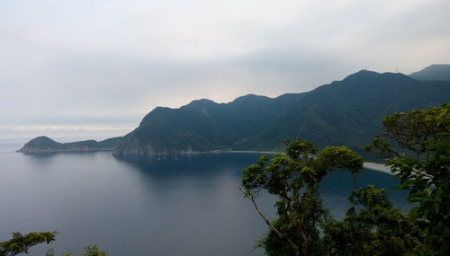 Scenic view of sea and mountains against sky