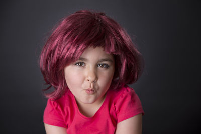 Close-up portrait of a girl against black background