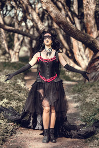 Portrait of young woman standing in forest