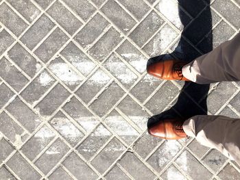 Low section of man standing on paved floor