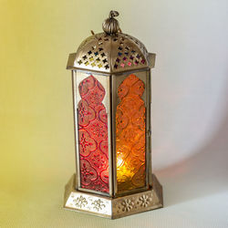 Close-up of lantern on table against wall