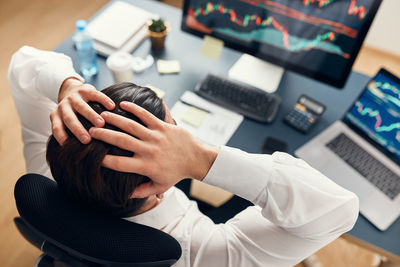 Worried businessman looking at charts stressed by news from stock market. investor lost money online