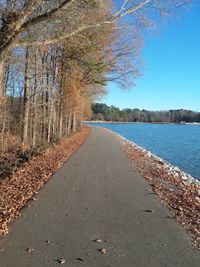 Road by lake against sky