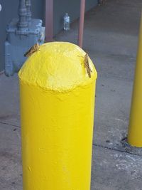 High angle view of yellow can on street against wall