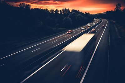 Blurred motion photo of highway against sky during sunset