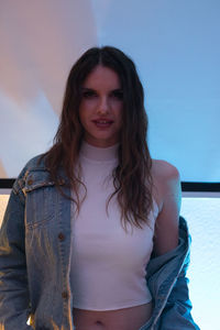 Portrait of smiling young woman standing against sky