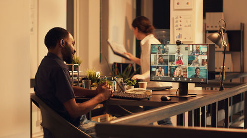 Side view of man using laptop at office