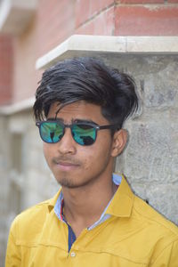 Portrait of handsome young man against wall