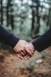 Midsection of couple holding hands