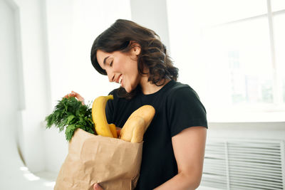 Young woman holding ice cream at home