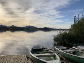 Boats moored on lake against sky