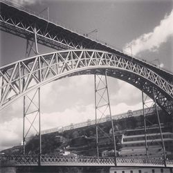 Low angle view of bridge against cloudy sky