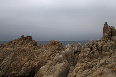 Rock formations in sea against sky