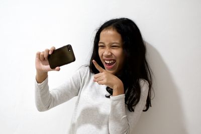 Portrait of smiling young woman using mobile phone