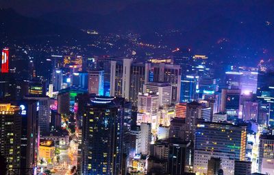 High angle view of illuminated city buildings at night