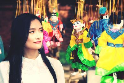 Woman looking at puppets hanging in market for sale