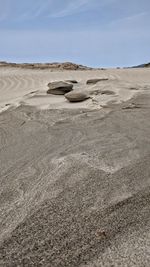 Sand at shore of beach against sky