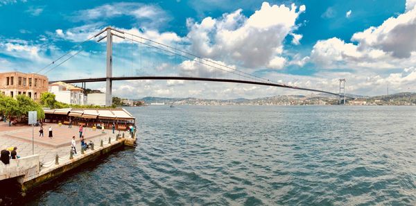 View of bridge over sea against cloudy sky