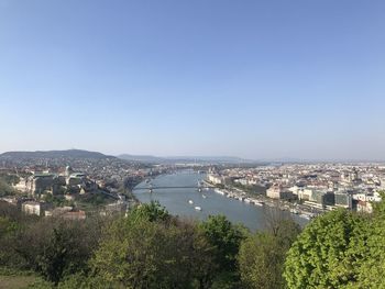 High angle view of townscape by river against clear sky