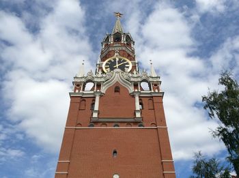 Low angle view of spasskaya tower against cloudy sky