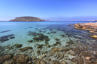 Scenic view of sea against clear blue sky