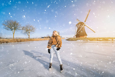 Full length of woman standing on snow against sky