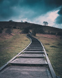 Steps leading towards mountain against sky