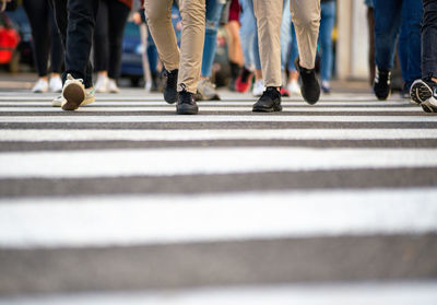 Low section of people walking on city street