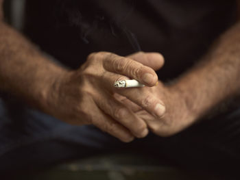 Close-up of man holding cigarette