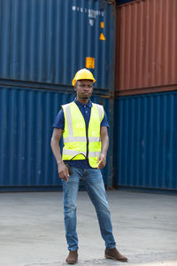 Full length portrait of young man standing on pier