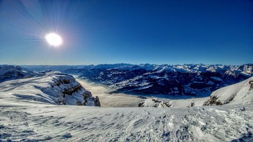 Scenic view of landscape against blue sky during winter