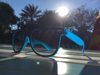 Close-up of sunglasses against blue sky