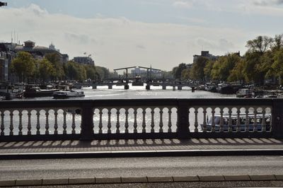 Bridge over river in city against sky
