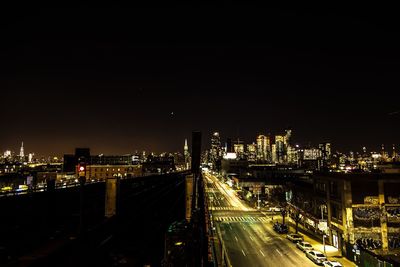 Illuminated bridge in city against sky at night