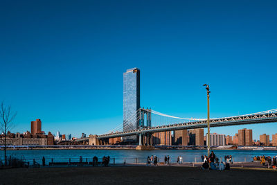 Bridge over river against clear blue sky