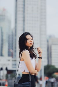 Young woman standing against city in background